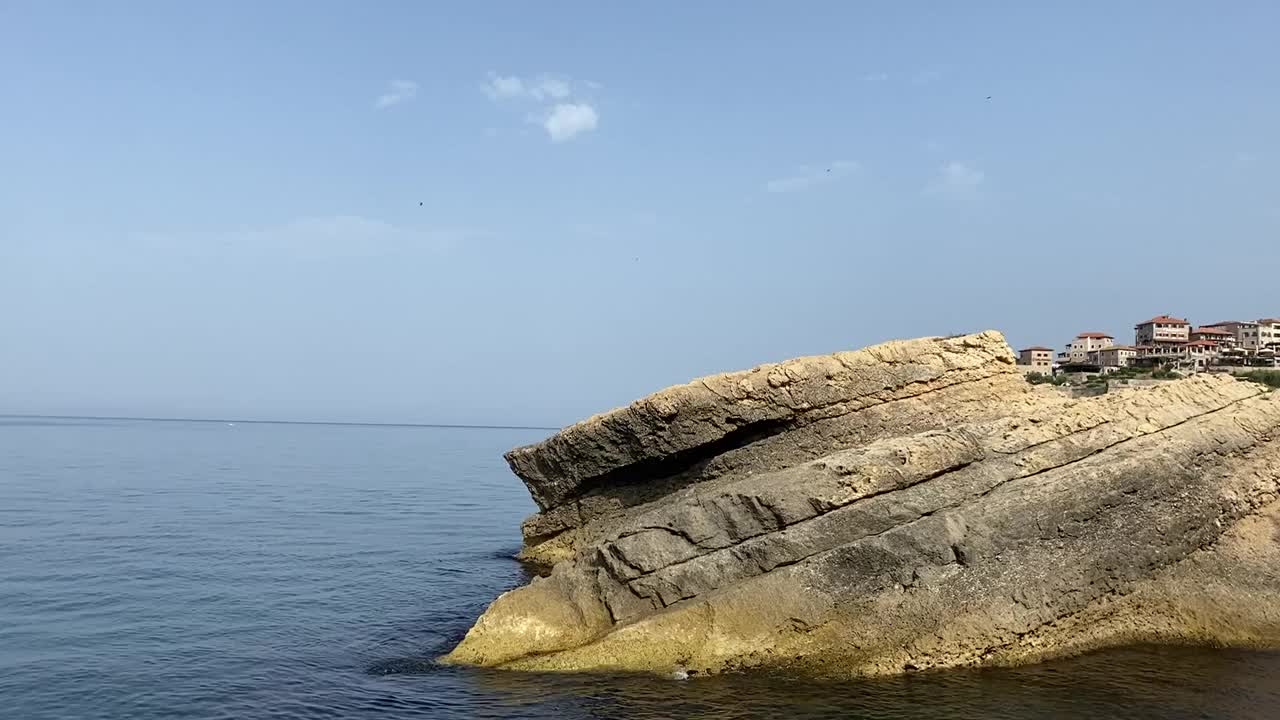 地中海岩石海岸。中世纪的古城在海岸悬崖和蓝色平静的海浪。古老的堡垒的观点。夏天。宁静。黑山。视频素材