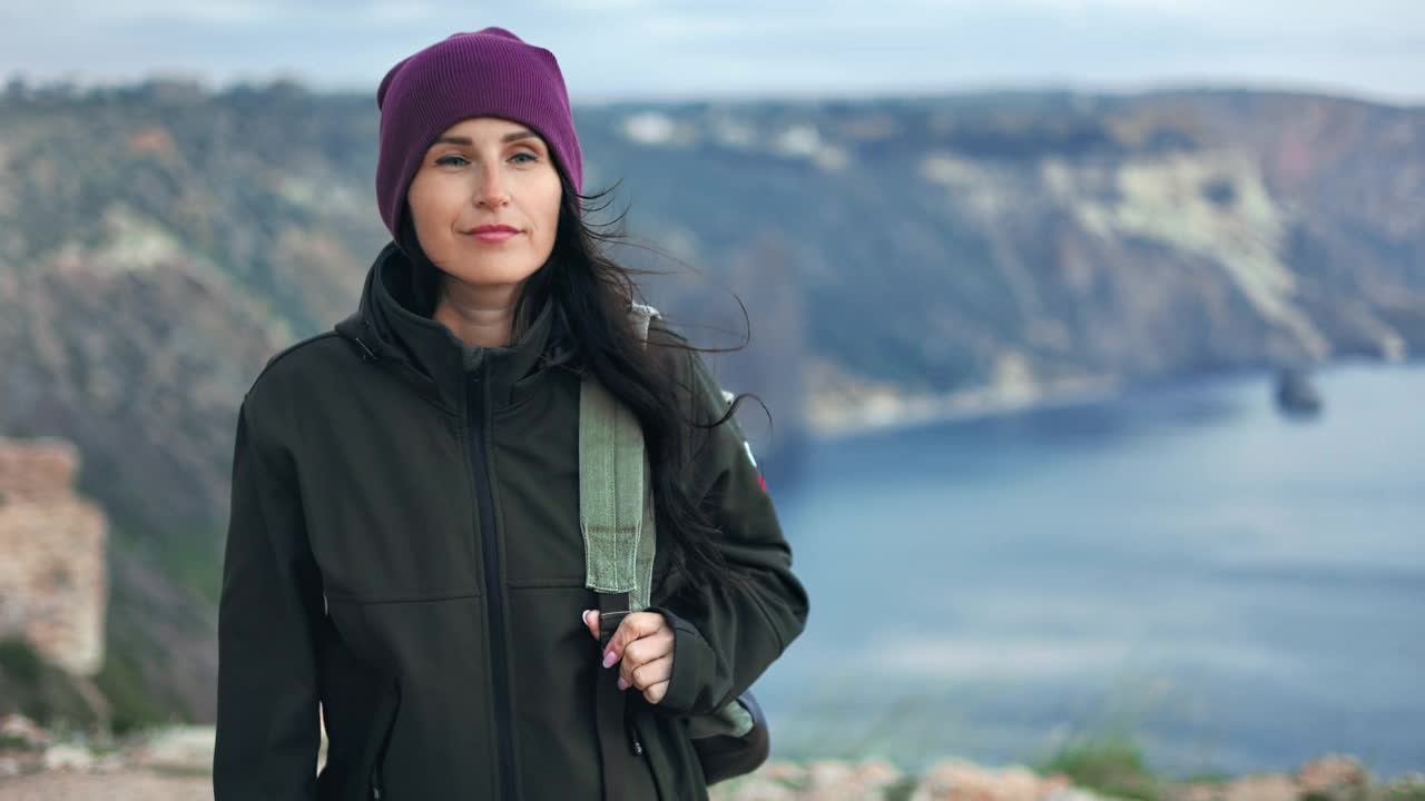 活跃的徒步女登山山顶欣赏自然海洋在大风天气极端旅行视频素材