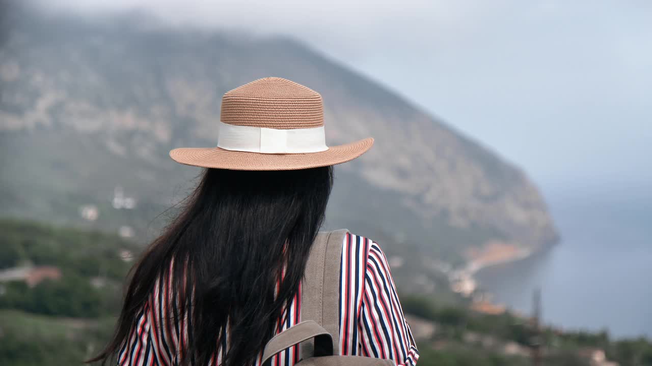 背景优雅的旅行女背包客从山顶欣赏美丽的海景视频素材