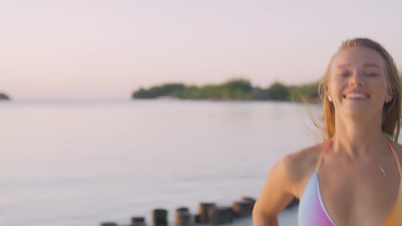 诱人的女人在沙滩上奔跑和玩耍。夏天的日落视频素材