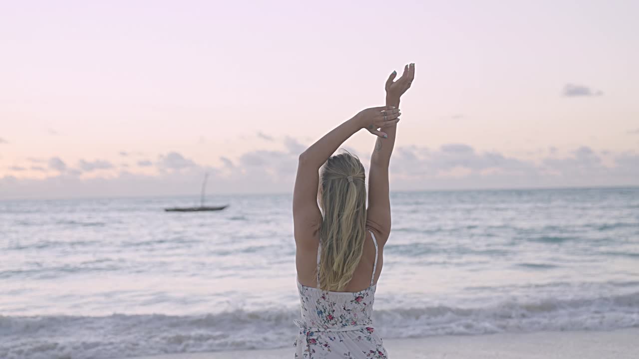 诱人的女人在夏天的衣服享受海滩日落视频素材