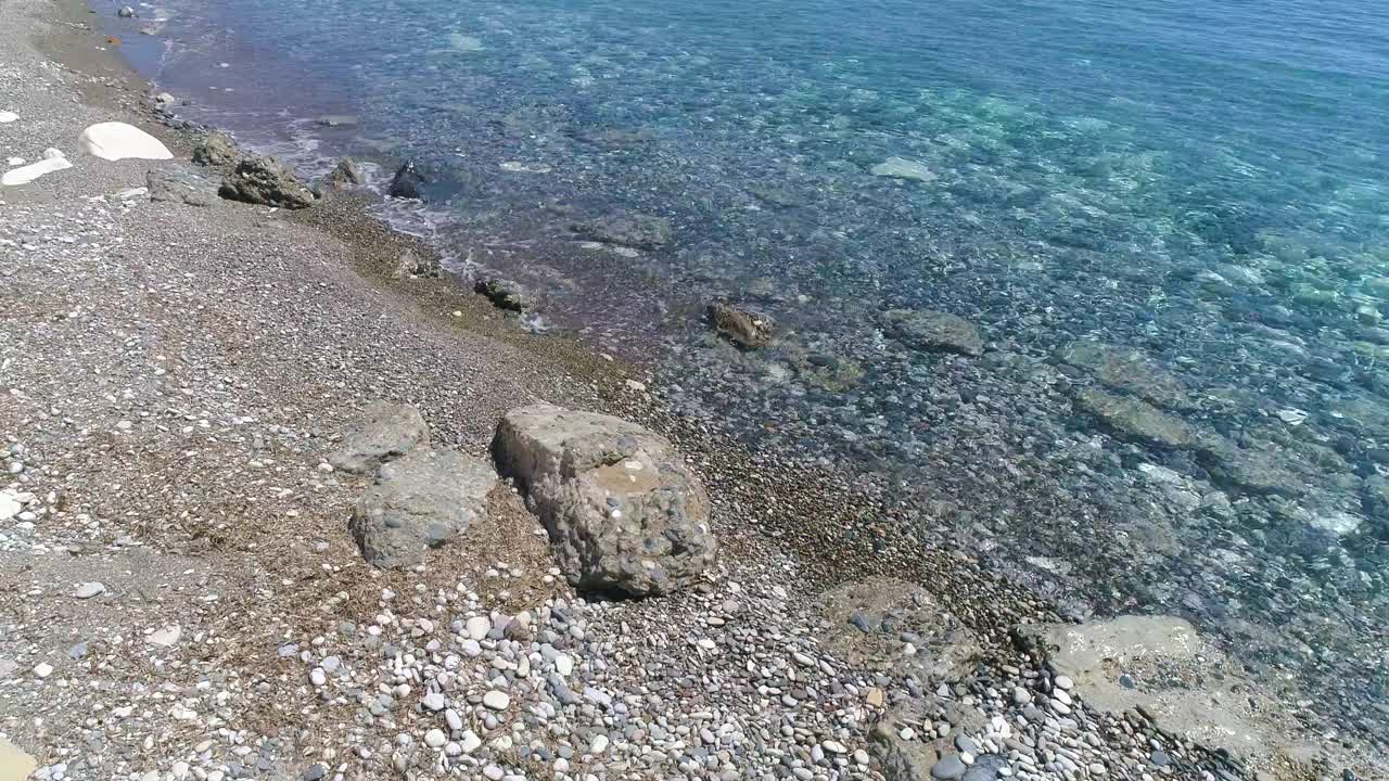 鸟瞰图，阳光明媚的日子在海或海洋海滩。在僻静的地方度假放松。夏日海景。地中海海滩。清水纹理。4K俯视图视频素材