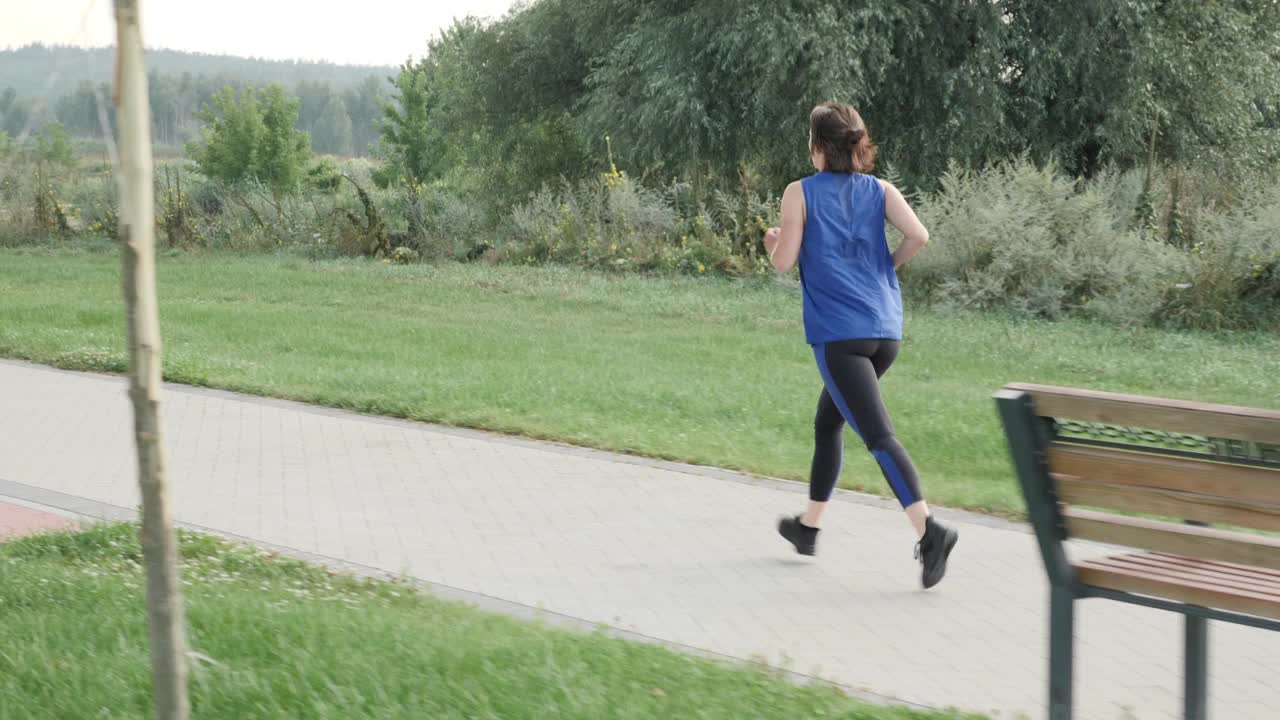 早上在城市公园跑步和慢跑。女人的户外锻炼。适合运动女性训练，有氧运动锻炼。健身健康积极生活理念。耐力训练视频素材