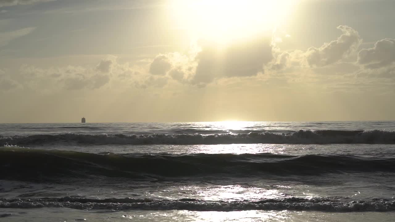 橙色的日落天空在海上和波浪翻滚的管道撞击海滩。视频素材