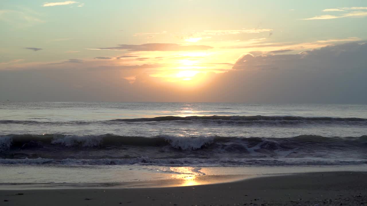 海边美丽的日落天空，海浪拍打着海滩。视频素材