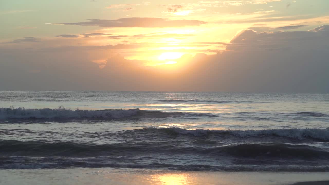 海边美丽的日落天空，海浪拍打着海滩。视频素材