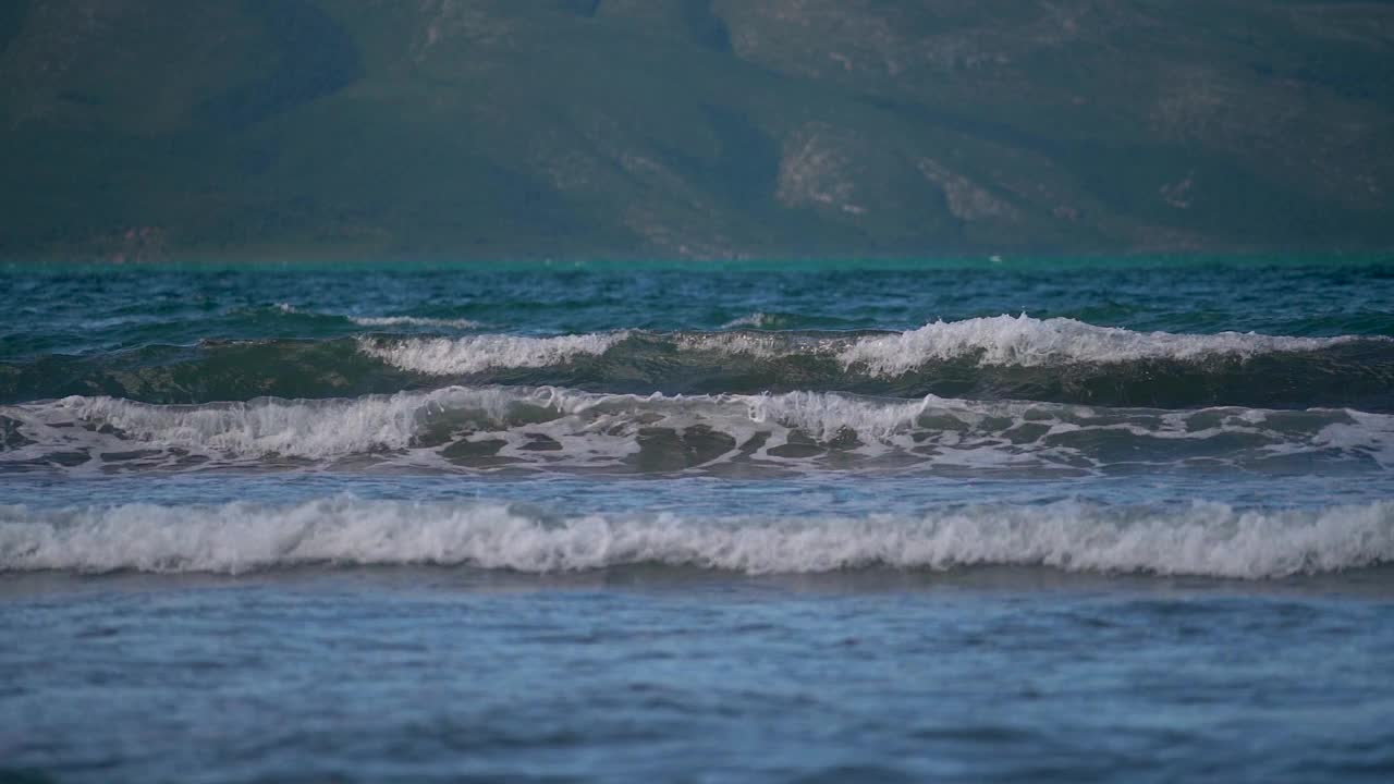 波光粼粼的海浪拍打着海滩，翻滚着。视频素材