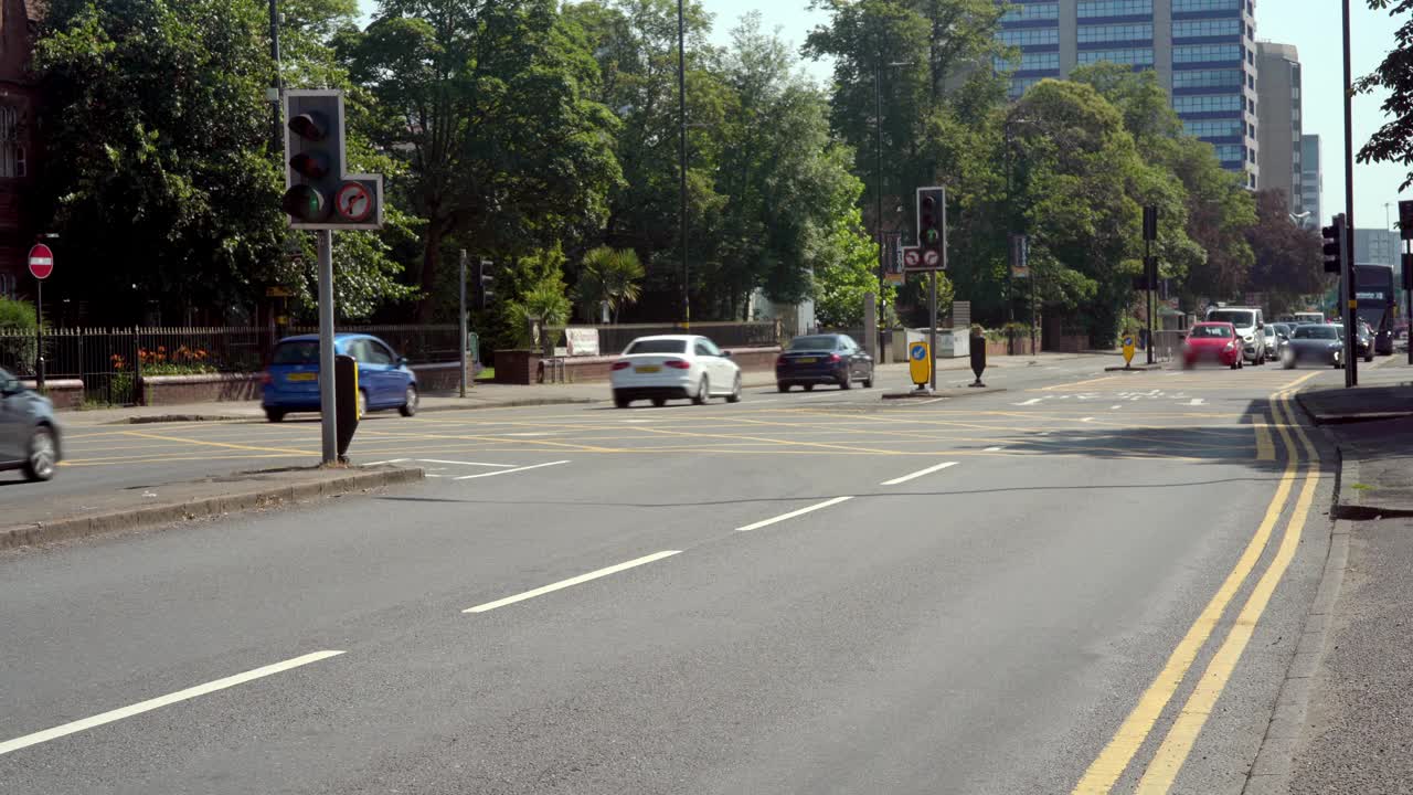 英国城市道路上的一个交通灯控制的路口。视频素材