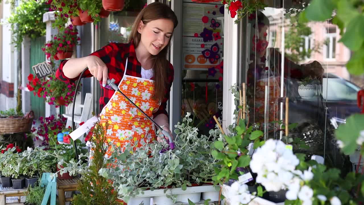 在城市街头花店或花店工作的年轻成年妇女。视频素材