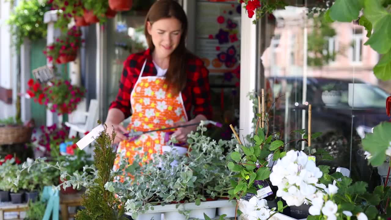 在城市街头花店或花店工作的年轻成年妇女。视频素材