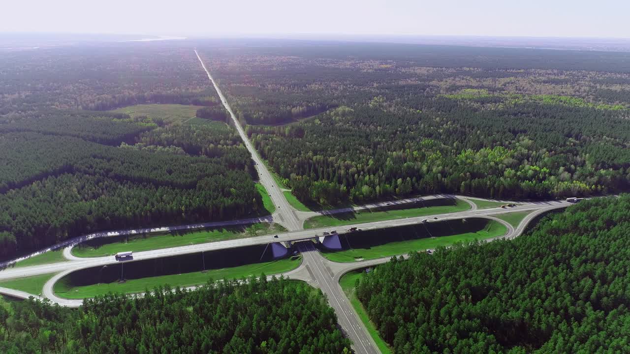 鸟瞰图交通十字路口与移动的汽车和卡车。运输交汇处，在针叶林的轨道。夏天阳光灿烂的日子视频素材