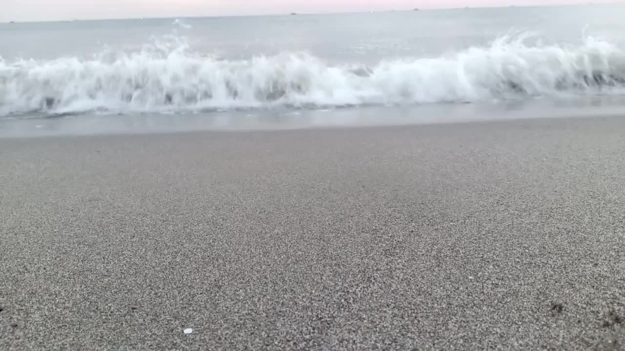 小波浪不断地拍打着海滩视频素材