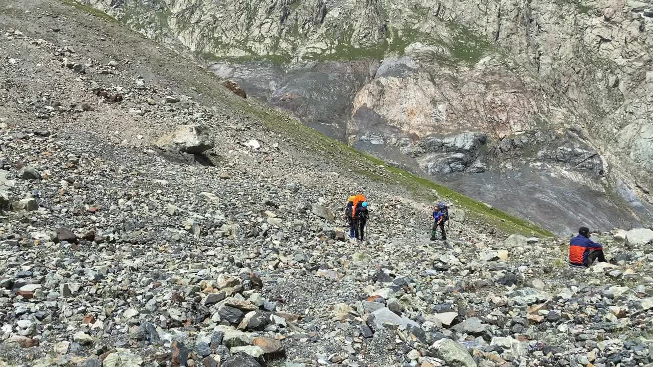 背着大背包的登山游客沿着山路向上看。视频素材