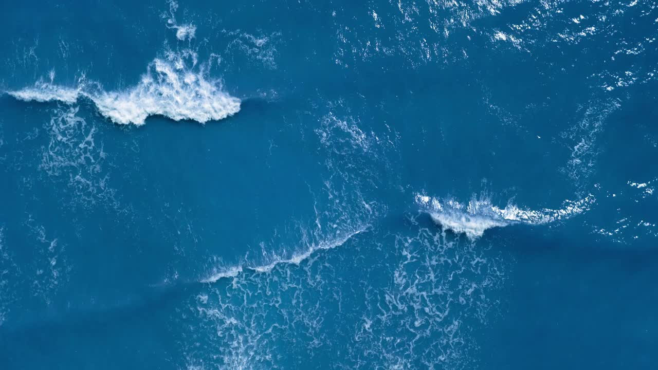 鸟瞰海或海洋与美丽的波浪图案和海泡沫。在夏天，无尽的海蓝宝石蓝色或蓝绿色海水的景观。视频素材