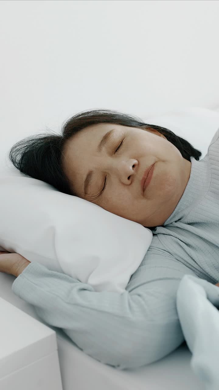 睡眠问题。老妇人睡不着。手持垂直拍摄。视频素材