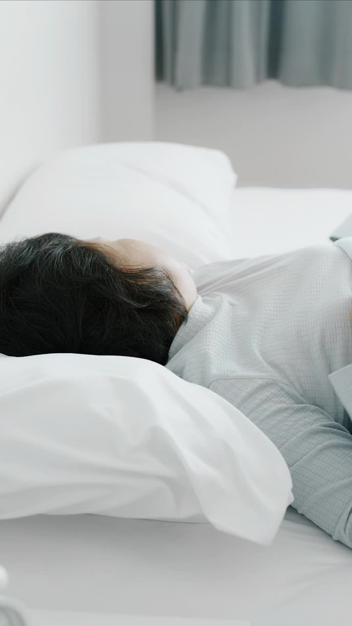 睡眠障碍。老妇人睡不着。手持垂直拍摄。视频下载