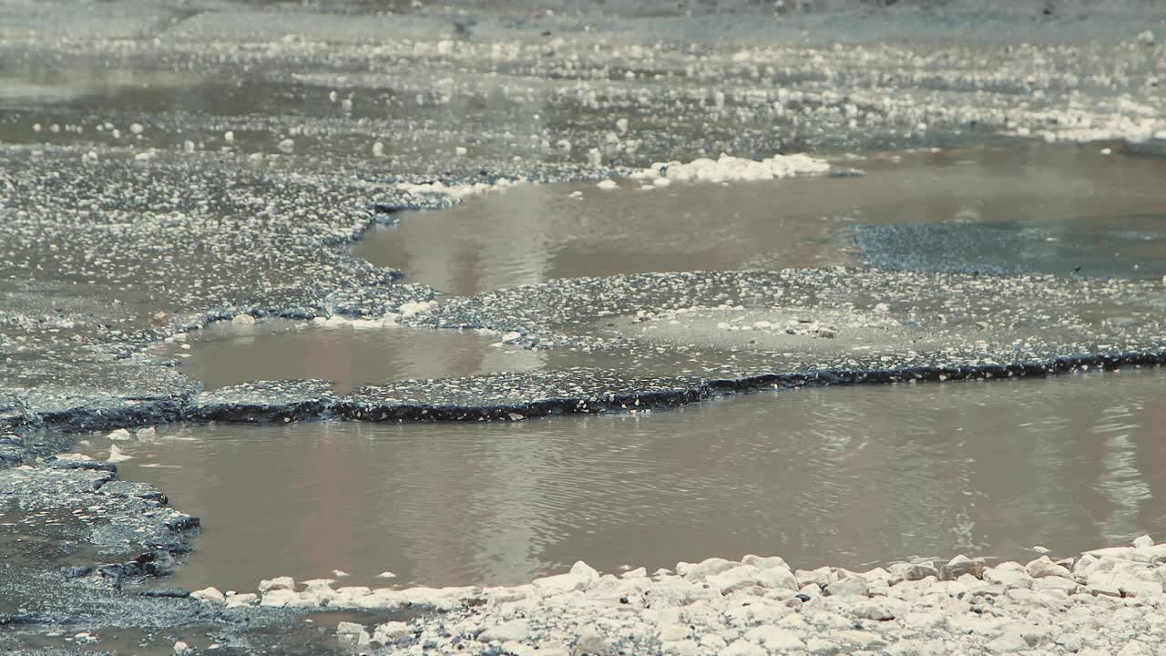 沥青路坑洼，道路基础设施在雨后遭到破坏视频素材