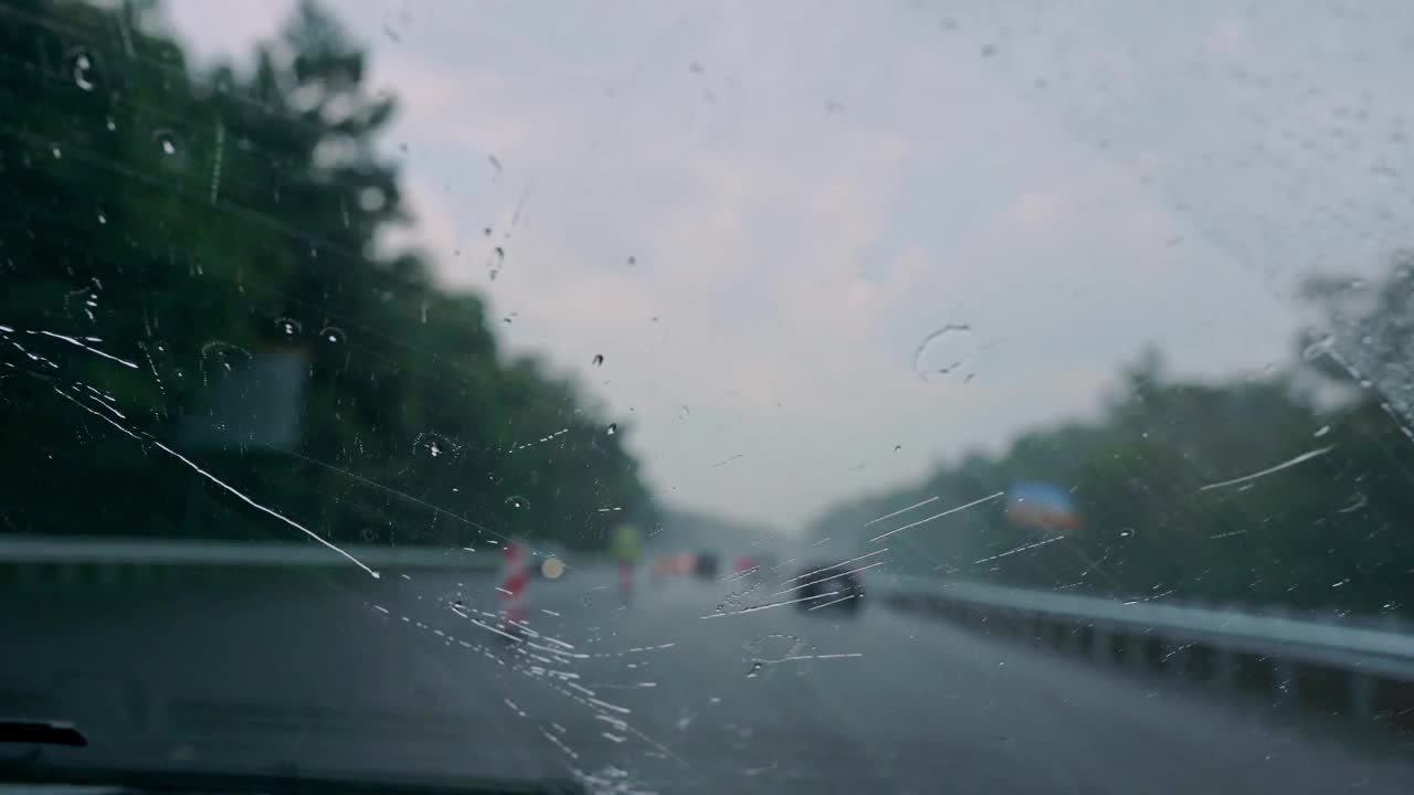 雨点会冲走挡风玻璃上的雨刷。天气不好时透过挡风玻璃看路视频素材