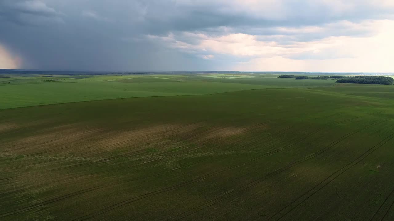 戏剧性的天空在下雨前与雨云在地平线上农村景观田野草地。视频素材