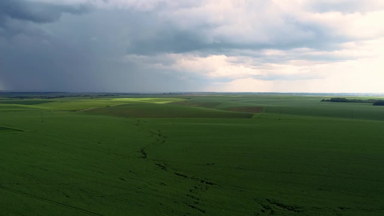 戏剧性的天空在下雨前与雨云在地平线上农村景观田野草地。视频素材