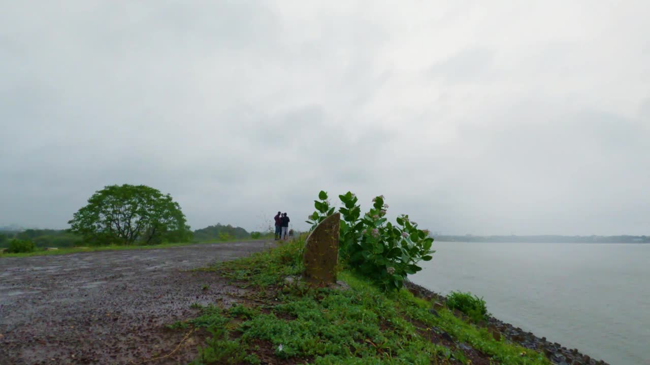 时间流逝的水填满了在天空中移动的土块。许多人在下雨天通过这条路。在古吉拉特邦拉杰果特的尼亚里大坝视频素材