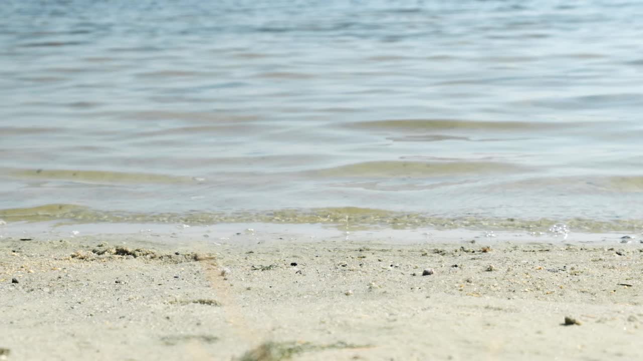 腿和脚在海水里。女人赤脚走在沙滩海岸线上，在沙滩上留下脚印。旅游的概念旅游旅游放松热带。慢镜头,特写视频素材