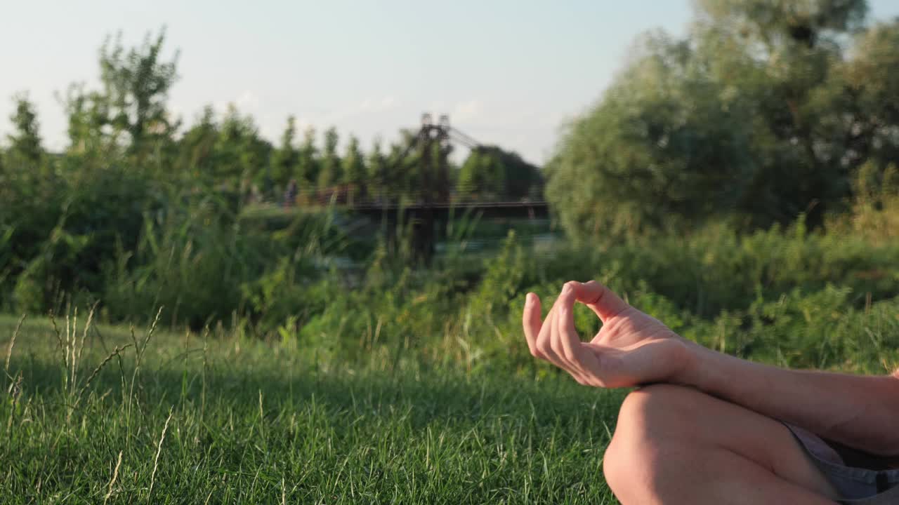 马德拉舞手的位置。冥想的人。年轻平静的男性坐在莲花位练习瑜伽。禅宗的概念。健康的生活方式。冥想在日落时分视频素材