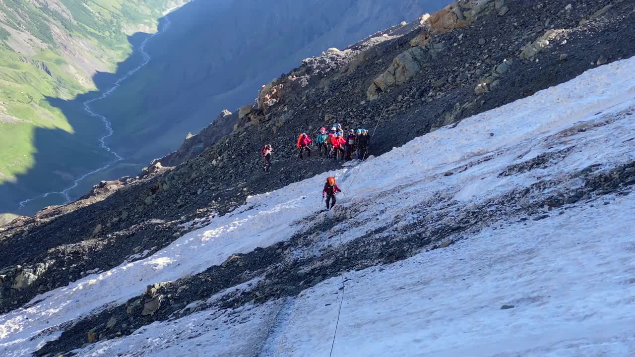 登山者沿着冰道穿过冰碛，用保护绳抓住绳子视频素材