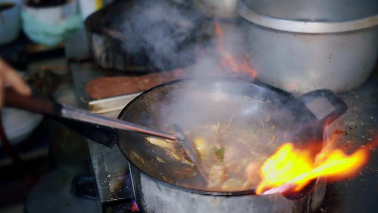 慢动作烹饪泰式食物红咖喱酱和香料辣炒猪在热锅煤气炉与火在厨房视频素材