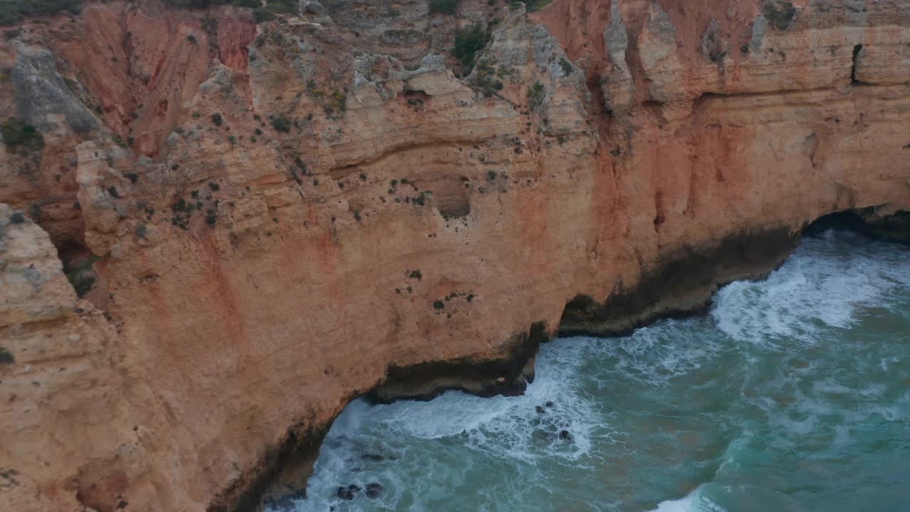 空中无人驾驶飞机俯瞰惊人的拉各斯大西洋海岸线，海浪泡沫撞击悬崖，葡萄牙，一天视频素材