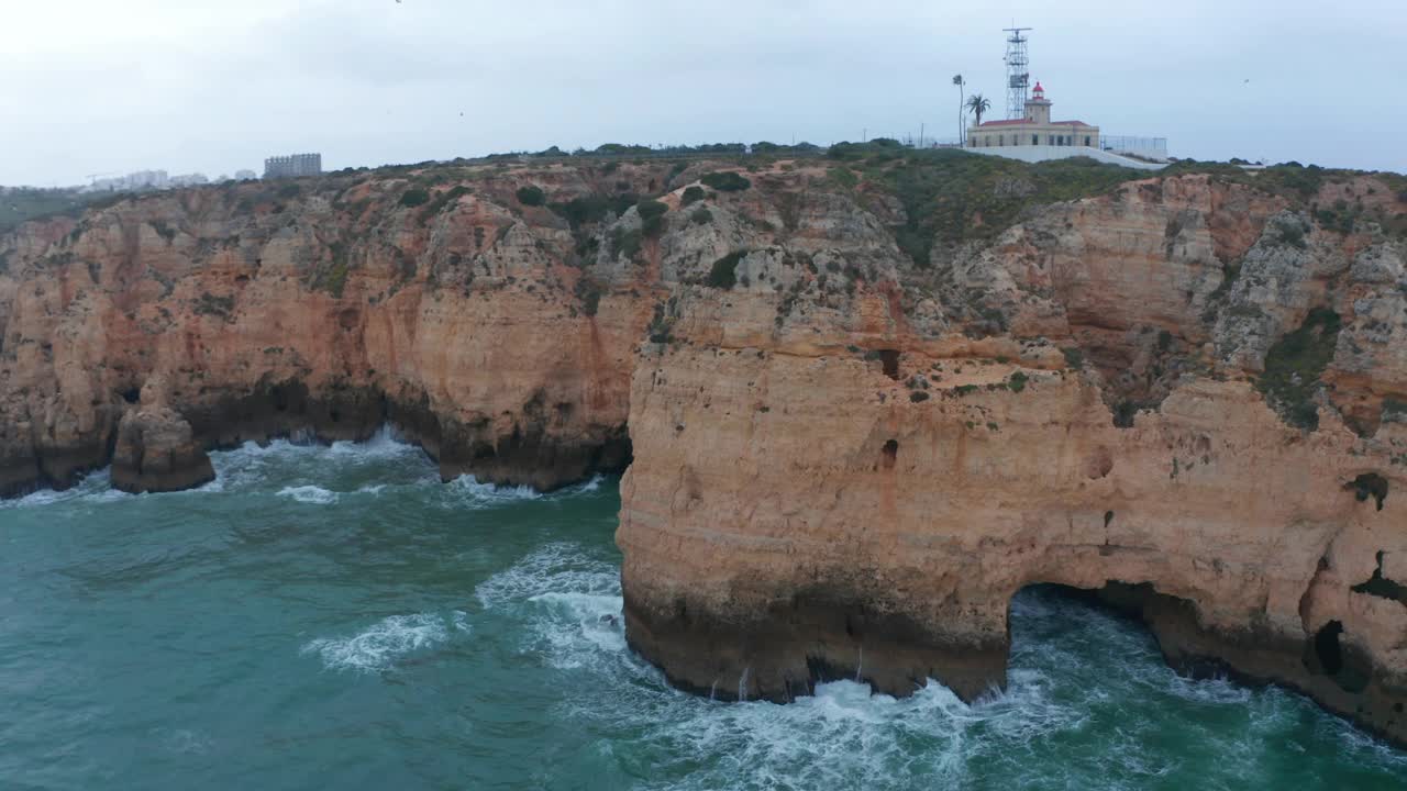 在拉各斯，阿尔加维，葡萄牙的岩石悬崖海岸，空中无人机倾斜下来，鸟的眼睛从顶向下，刮风的日子视频素材