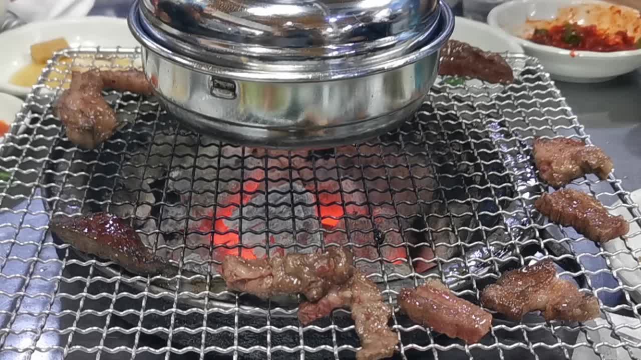 在豪华的韩式牛排烧烤(BBQ)餐厅里，新鲜的和牛牛肉在炭火上烧烤。视频下载