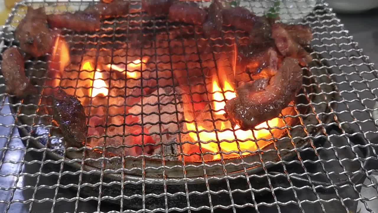 在豪华的韩式牛排烧烤(BBQ)餐厅里，新鲜的和牛牛肉在炭火上烧烤。视频下载