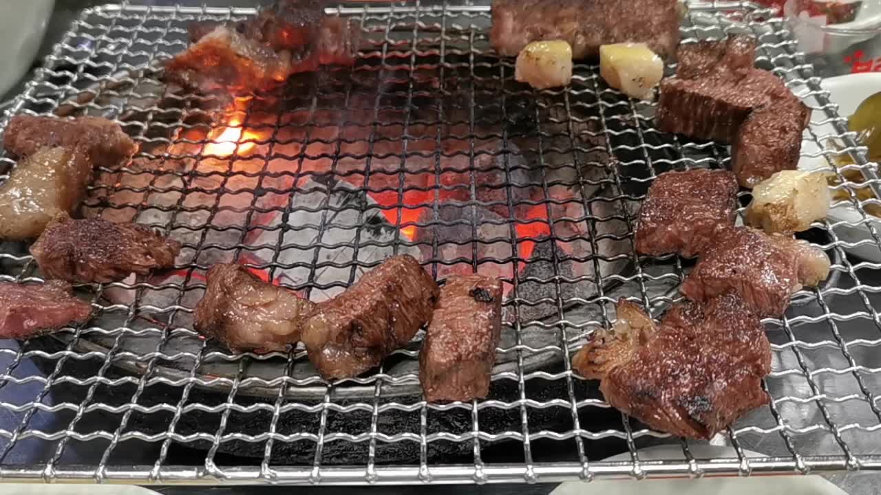 在豪华的韩式牛排烧烤(BBQ)餐厅里，新鲜的和牛牛肉在炭火上烧烤。视频下载