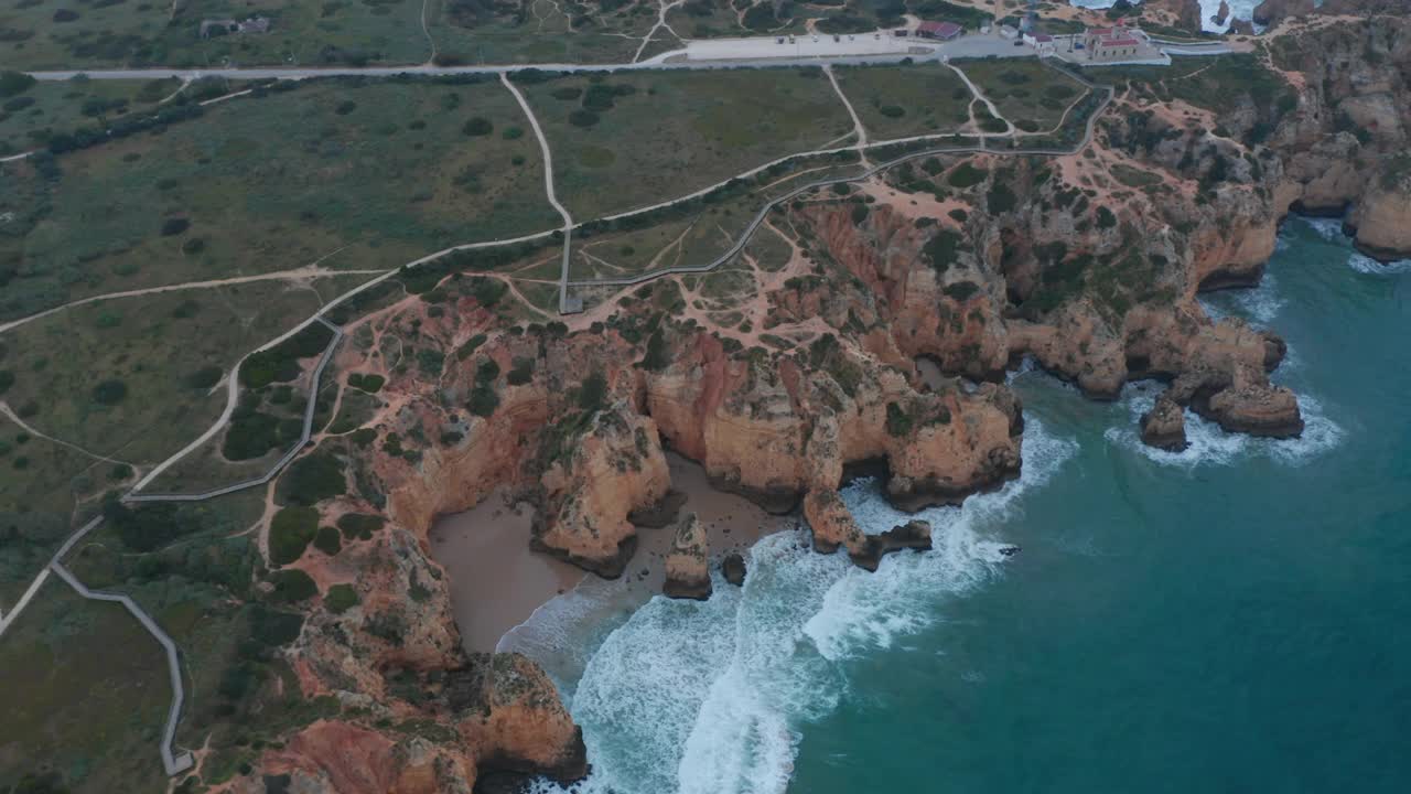 在多云的天气里，在葡萄牙拉各斯的户外海岸线上空盘旋，建立无人机视野视频素材