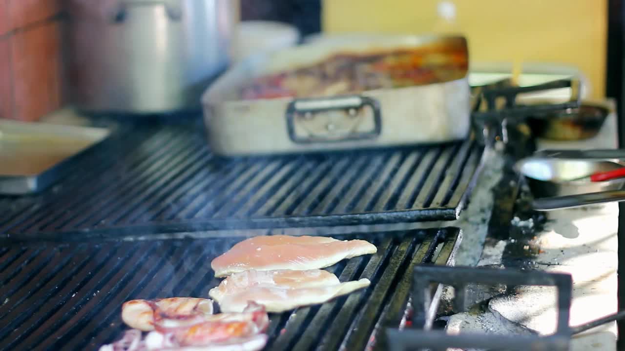 厨师在商业厨房炭烤架上烤鸡胸肉视频素材