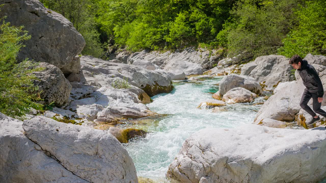 年轻人在壮丽的风景中跳过山河视频素材