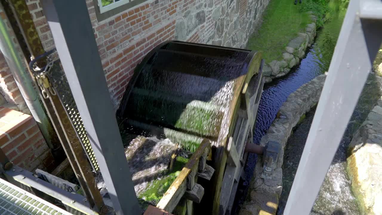 历史悠久的水厂的木磨轮在小溪的流水中转动视频素材