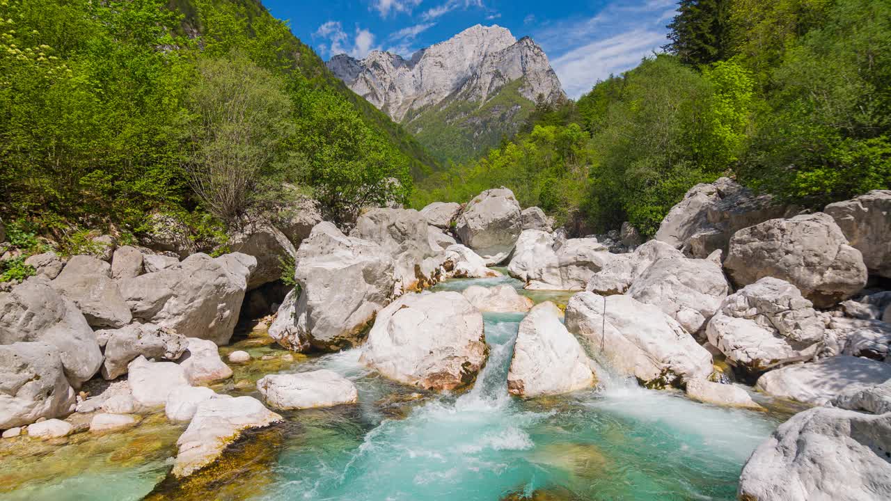 在一个阳光明媚的夏日，宏伟的绿色山河山谷视频素材