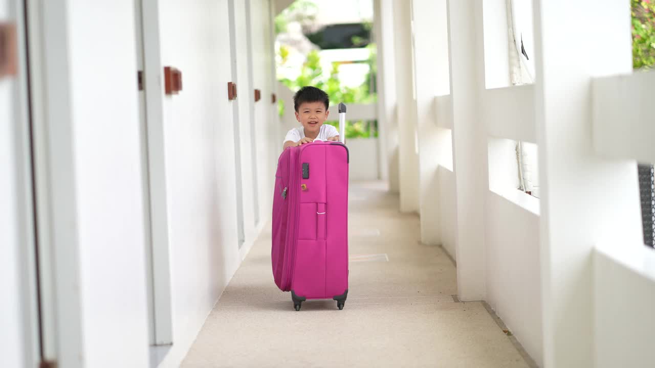 亚洲小孩在酒店拿行李。旅游和度假的概念视频素材