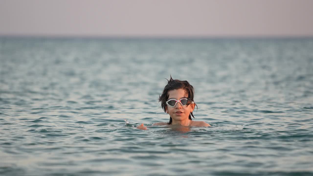 小男孩在海浪中玩耍和戏水视频素材