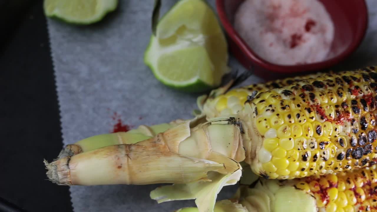 4K视频烤甜玉米，撒上盐，红辣椒和酸橙汁。视频素材