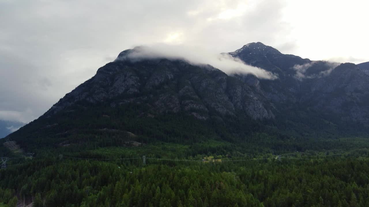 飞过长满青松的山谷和群山，远处云层低垂视频素材