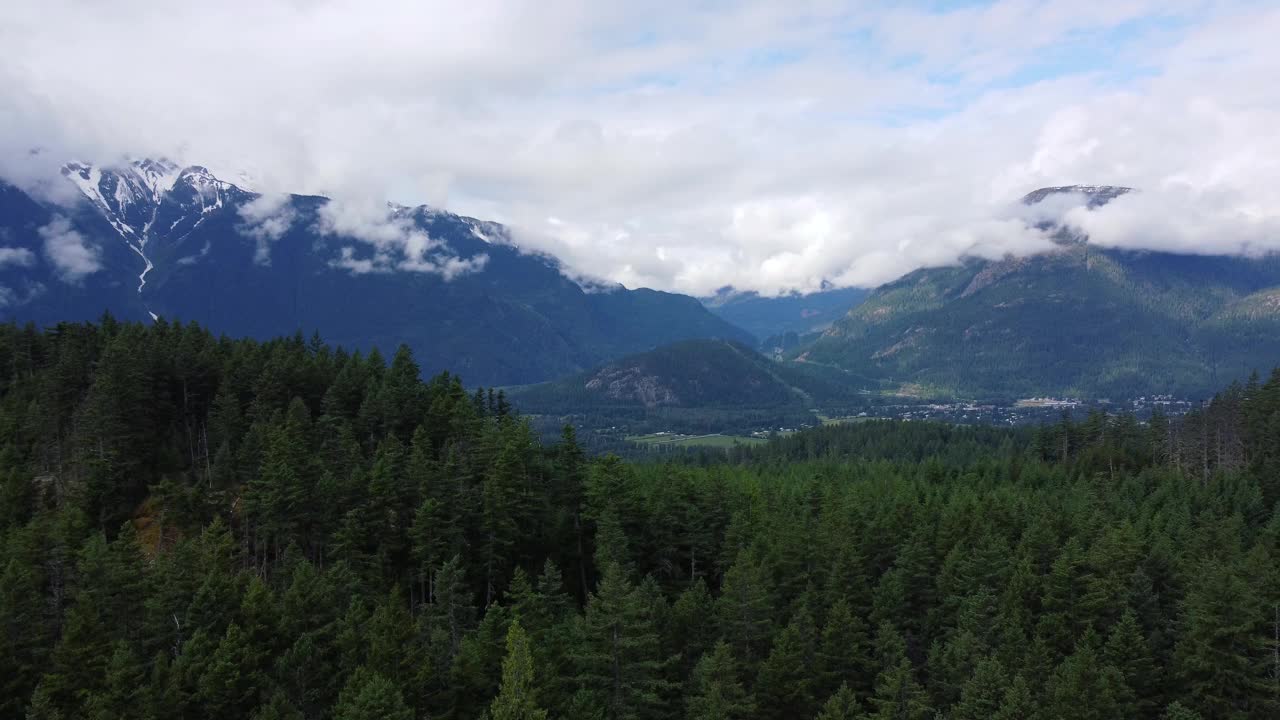 空中拍摄的小村庄在山谷之间的山和绿色的小山视频素材