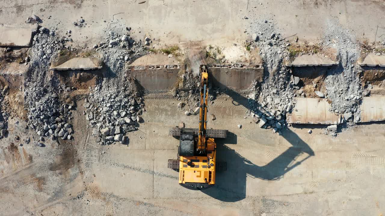 液压锤正在拆除建筑工地的混凝土。工程机械。鸟瞰图视频素材