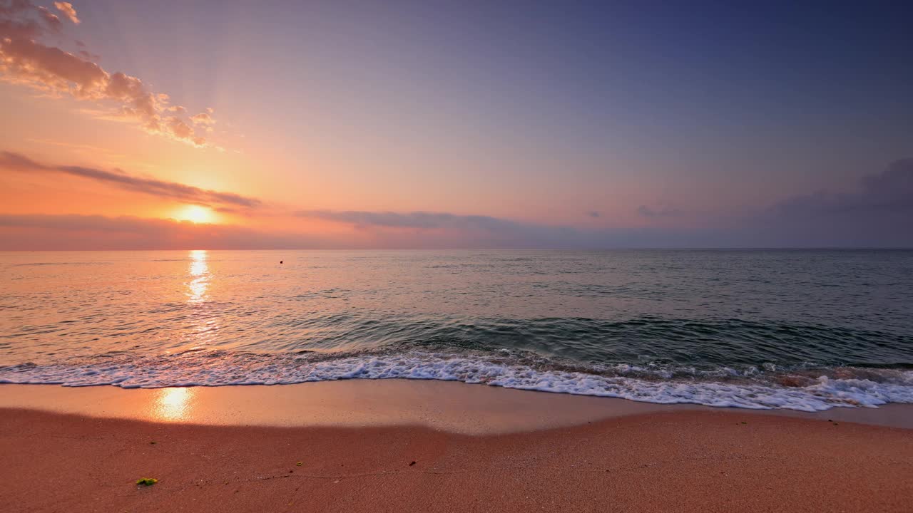 五颜六色的日出在海浪和热带海滩上。海景观。视频素材