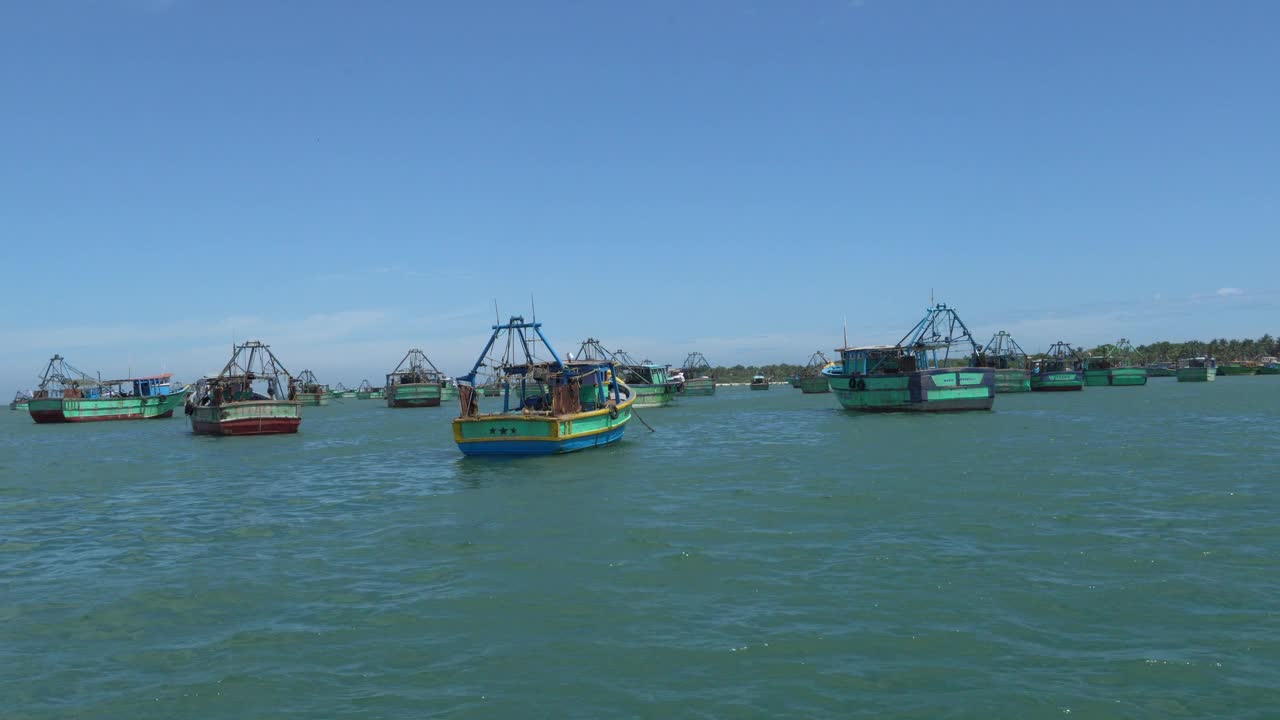 一大片蔚蓝的海洋海滩海水与渔船站在蓝色的天空。视频下载