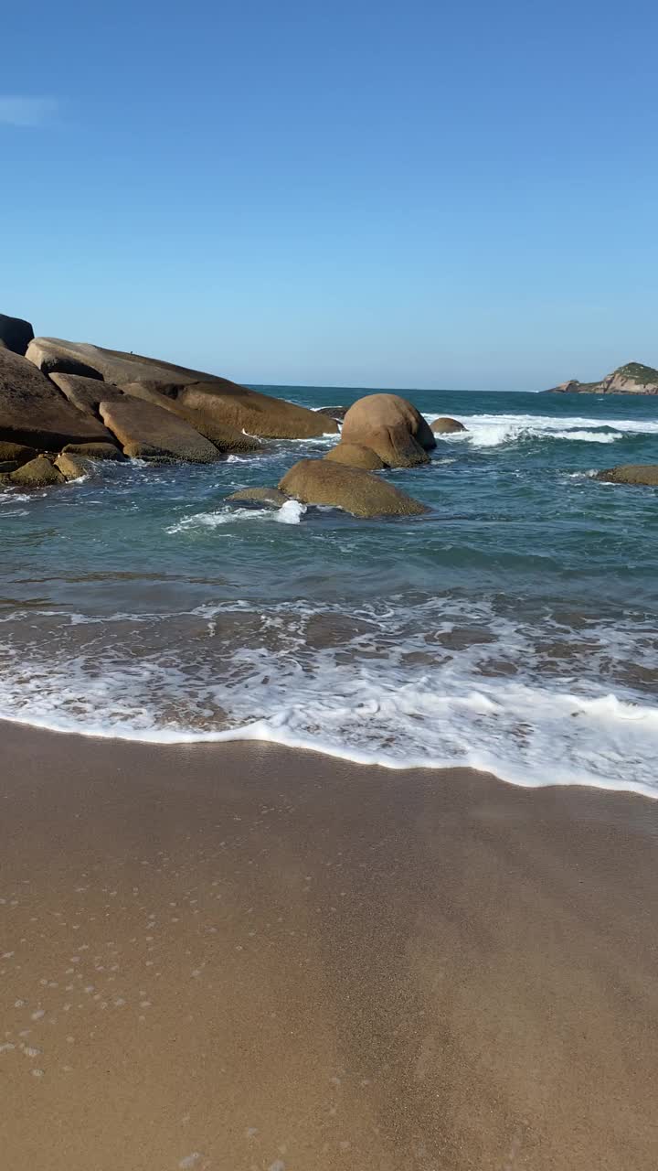 在阳光明媚的日子里，海滩上美丽的波浪景观。垂直视频。视频素材