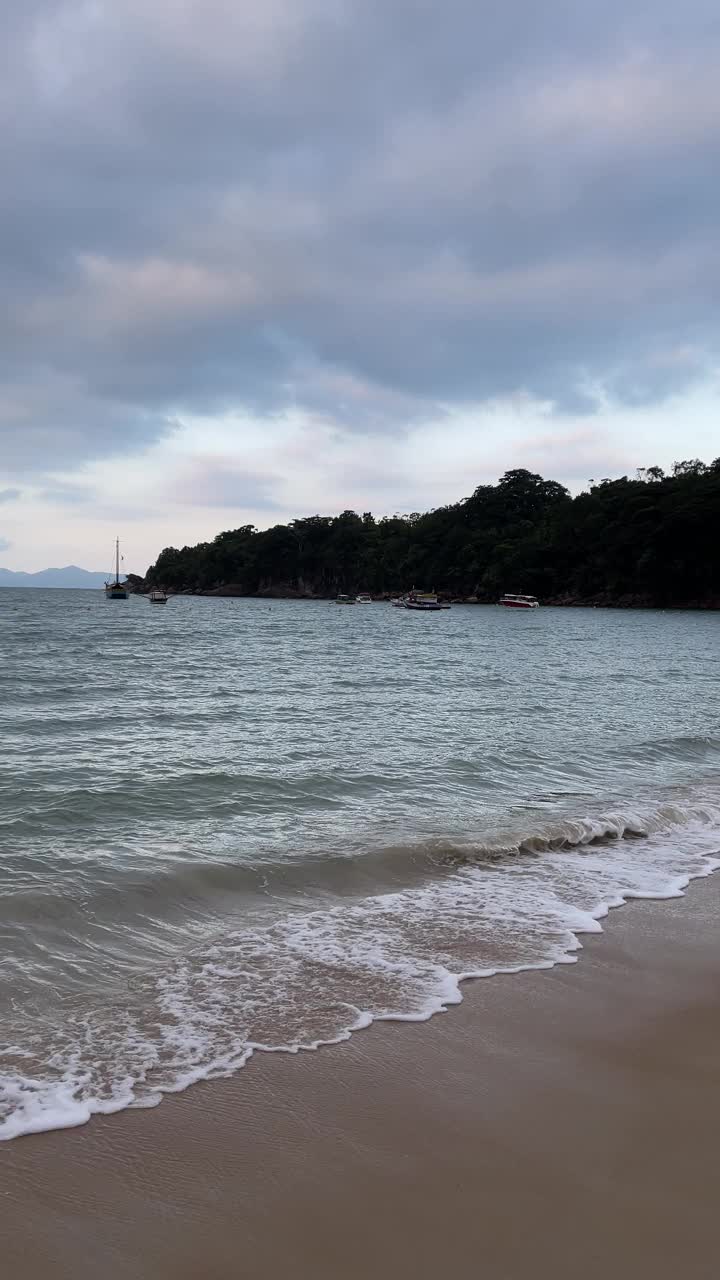 在阳光明媚的日子里，海滩上美丽的波浪景观。垂直视频。视频素材