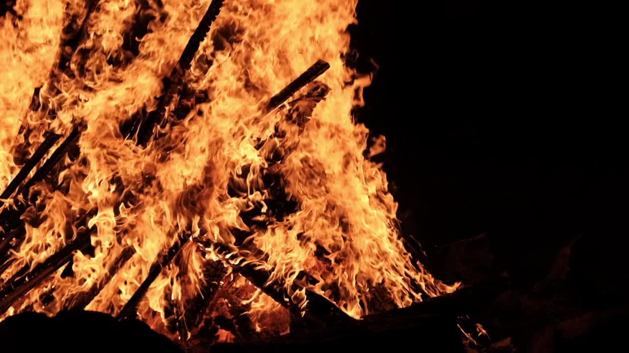 大篝火在夜晚燃烧在一个黑色背景慢动作视频素材